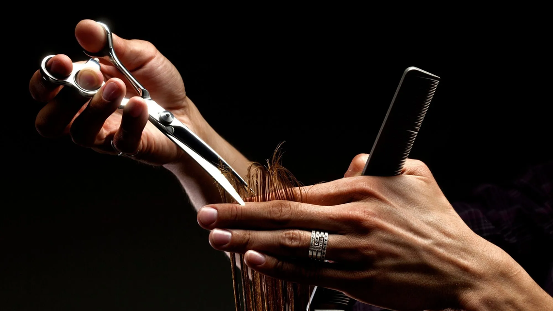 Friseur schneidet Kundin die Haare | ©  Adobe Stock/Ostap Senyuk