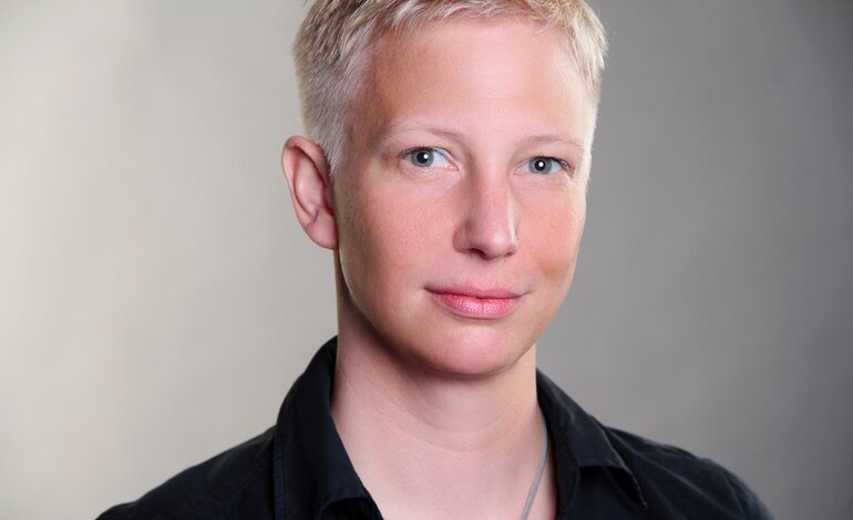 Frau mit kurzen blonden Haaren lächelt in die Kamera.  | © Privat