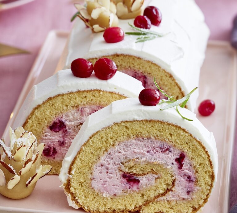 Auf einem Teller liegt eine  Marzipan-Cranberryrolle. Sie ist mit frischen Beeren und Marzipan verziert. | © EAT CLUB / Isabell Triemer