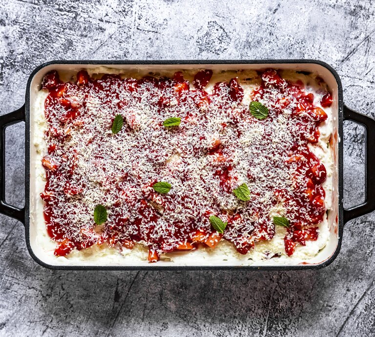 Von oben Ansicht einer Erdbeer-Lasagne, bestreut mit Schokoraspel aus weißer Schokolade. | © Getty Images/lacaosa