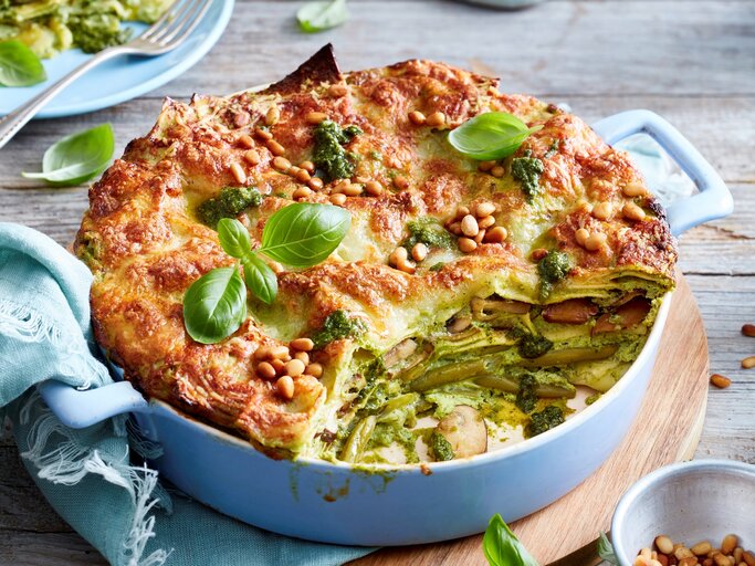 Ein hellblauer Topf mit Pesto-Lasagne auf einem Holzbrett. | © EAT CLUB/Isabell Triemer