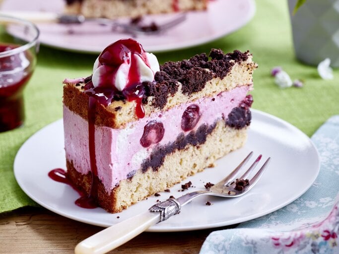 Auf einem Teller steht ein Stück Kiba-Streuseltorte. Es ist mit einem Klecks Schlagsahne verfeinert. | © EAT CLUB / Isabell Triemer