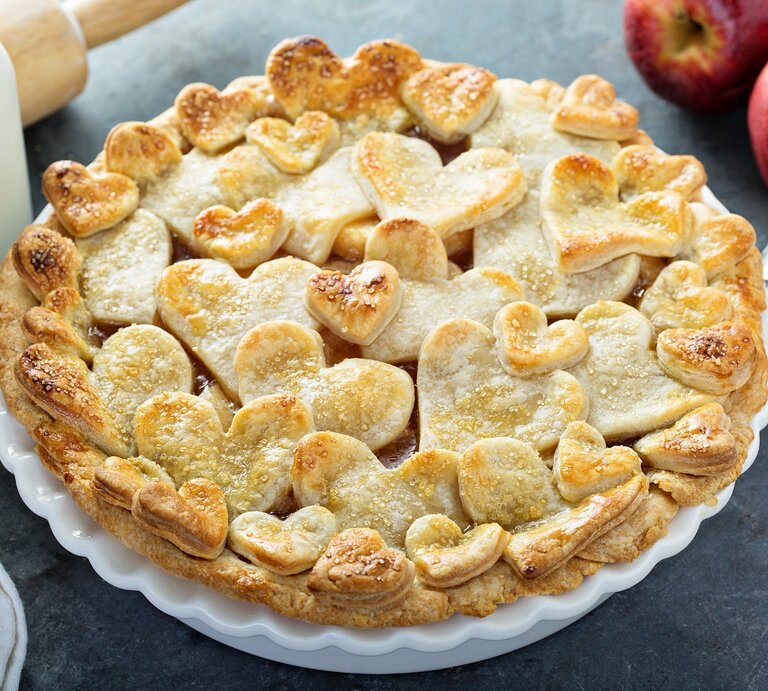 Auf einem Teller ist ein Apfel-Gitterkuchen mit Herzen serviert. Er hat Teigförmige Herzen oben drauf. | © Adobe Stock / fahrwasser