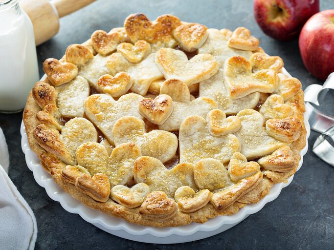 Auf einem Teller ist ein Apfel-Gitterkuchen mit Herzen serviert. Er hat Teigförmige Herzen oben drauf. | © Adobe Stock / fahrwasser