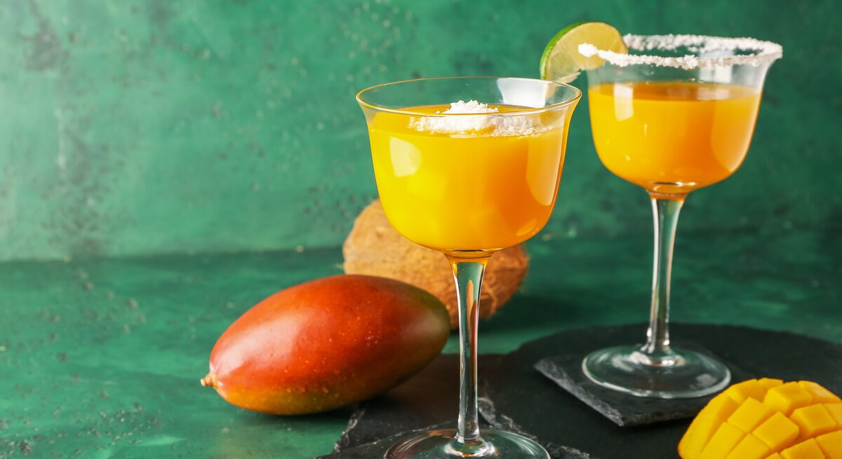 Zwei Gläser mit Mango-Margarita und Salzrand. 