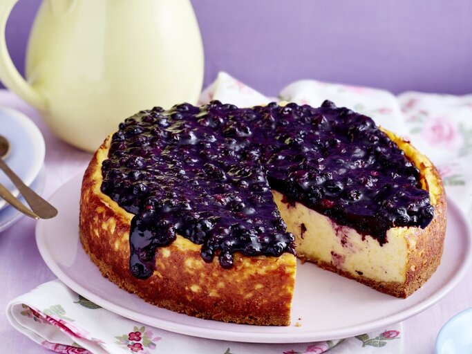 Auf einem Teller steht ein Heidelbeer-Pudding-Kuchen. Er ist sehr cremig und mit Heidelkompott bedeckt. | © EAT CLUB / Isabell Triemer 