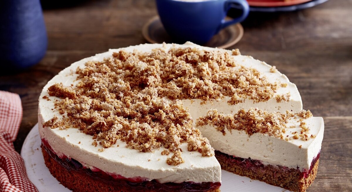 Auf einem Teller liegt eine angeschnittene Capucino-Krümeltorte. Sie ist cremig und fluffig.