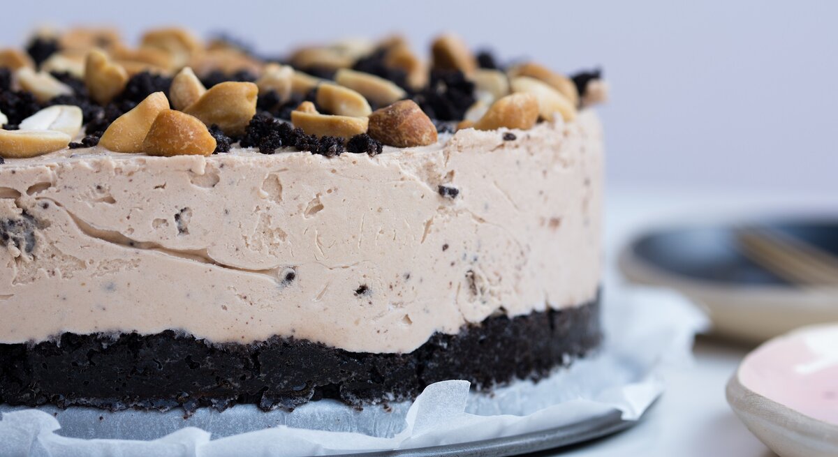 Ein Erdnussbutter-Cheesecake mit gehackten Erdnüssen dekoriert.