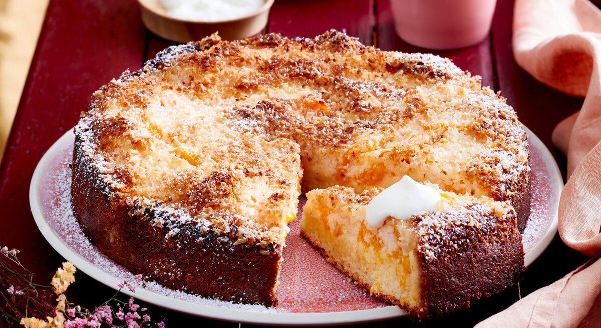 Mandarinen-Becher-Kuchen auf Teller serviert und angeschnitten.