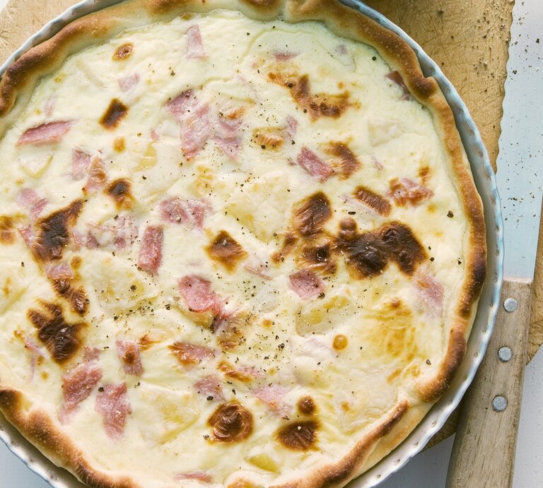 In einer runden Form ist eine Quiche Hawaii angerichtet. Sie ist mit Schinken und Ananas zubereitet. | © StockFood / Wissing, Michael