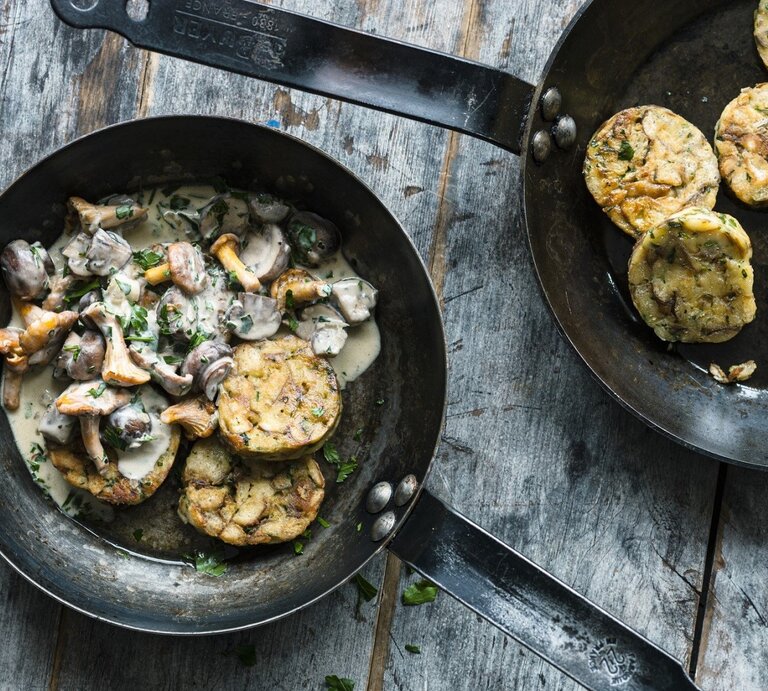 Auf einem Teller ist eine Portion bayerisches Pilzragout mit Brezenknödeln angerichtet. Daneben steht eine Pfanne mit weiteren Knödeln.  | © StockFood / Gräfe & Unzer Verlag / Schardt, Wolfgang