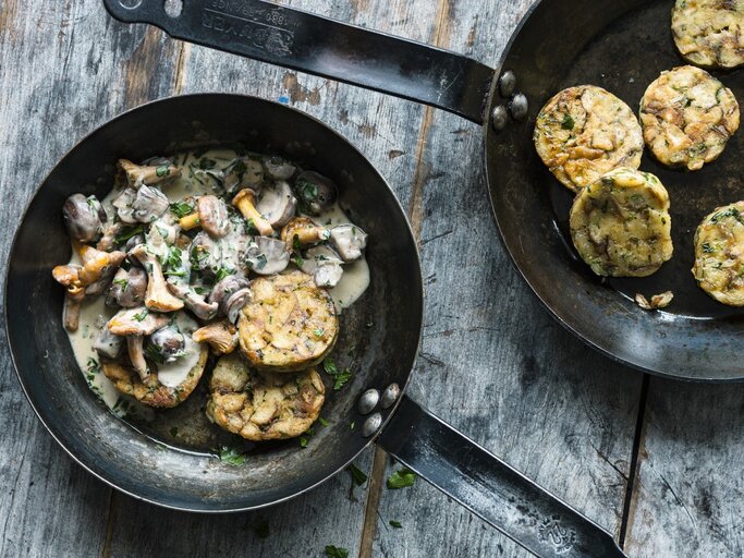 Auf einem Teller ist eine Portion bayerisches Pilzragout mit Brezenknödeln angerichtet. Daneben steht eine Pfanne mit weiteren Knödeln.  | © StockFood / Gräfe & Unzer Verlag / Schardt, Wolfgang