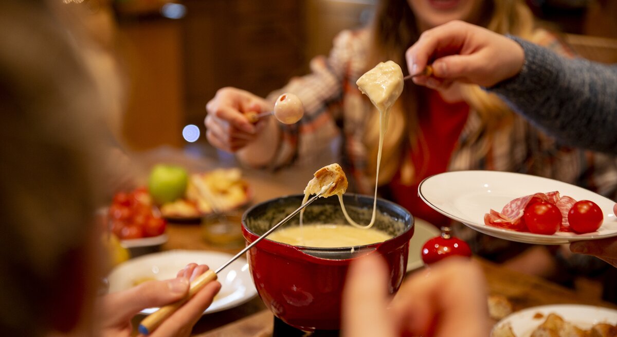 Menschen essen Käse-Fondue. 