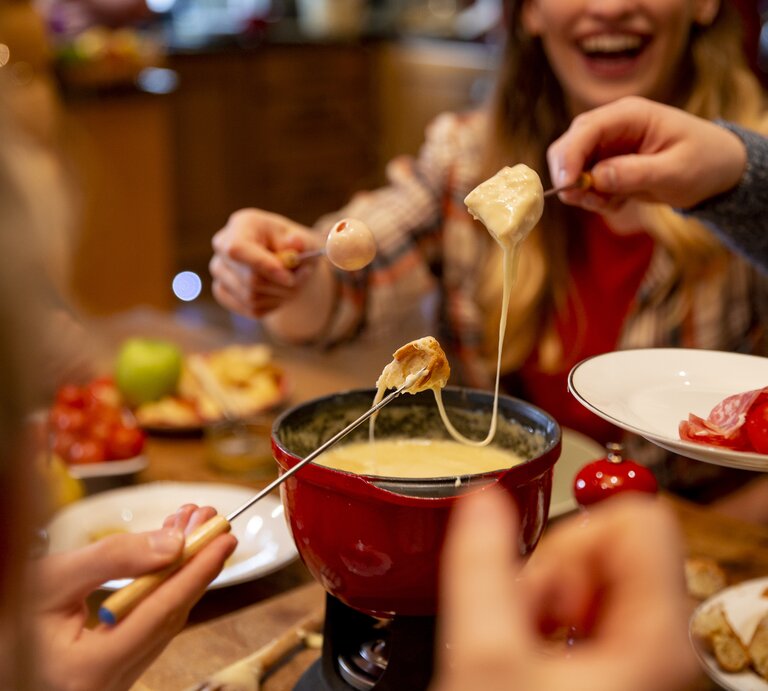 Menschen essen Käse-Fondue.  | © Getty Images/SolStock