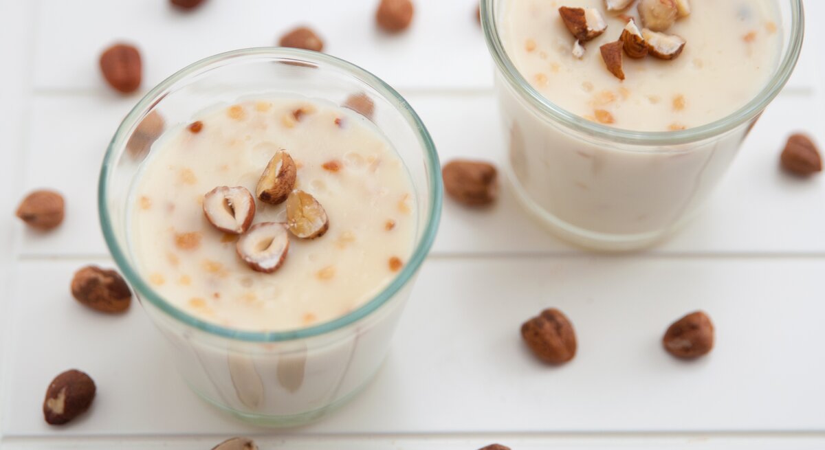 Zwei Gläser mit der Lebkuchen-Mousse und den gehackten Haselnüssen on top.