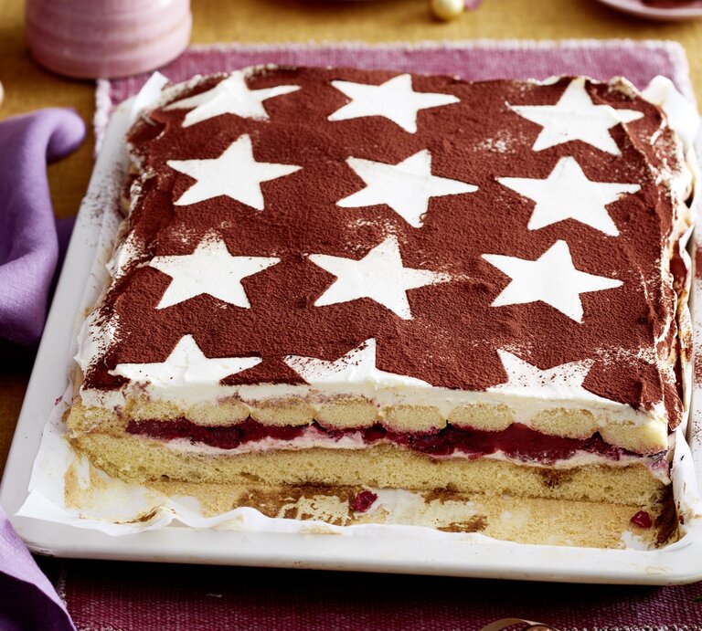 Glühwein-Tiramisu-Schnitten serviert auf einem weißen Teller, daneben weihnachtliche Deko-Elemente.  | © EAT CLUB/Isabell Triemer