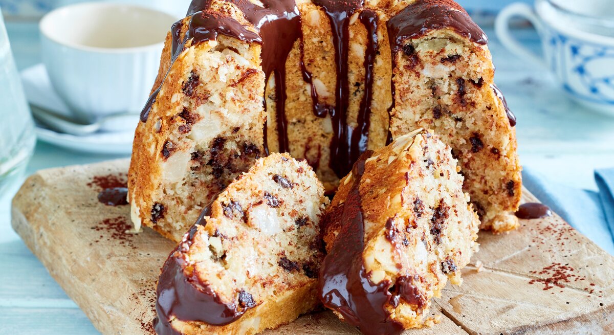 Birne-Helene-Gugelhupf auf einem Holzbrett angeschnitten.