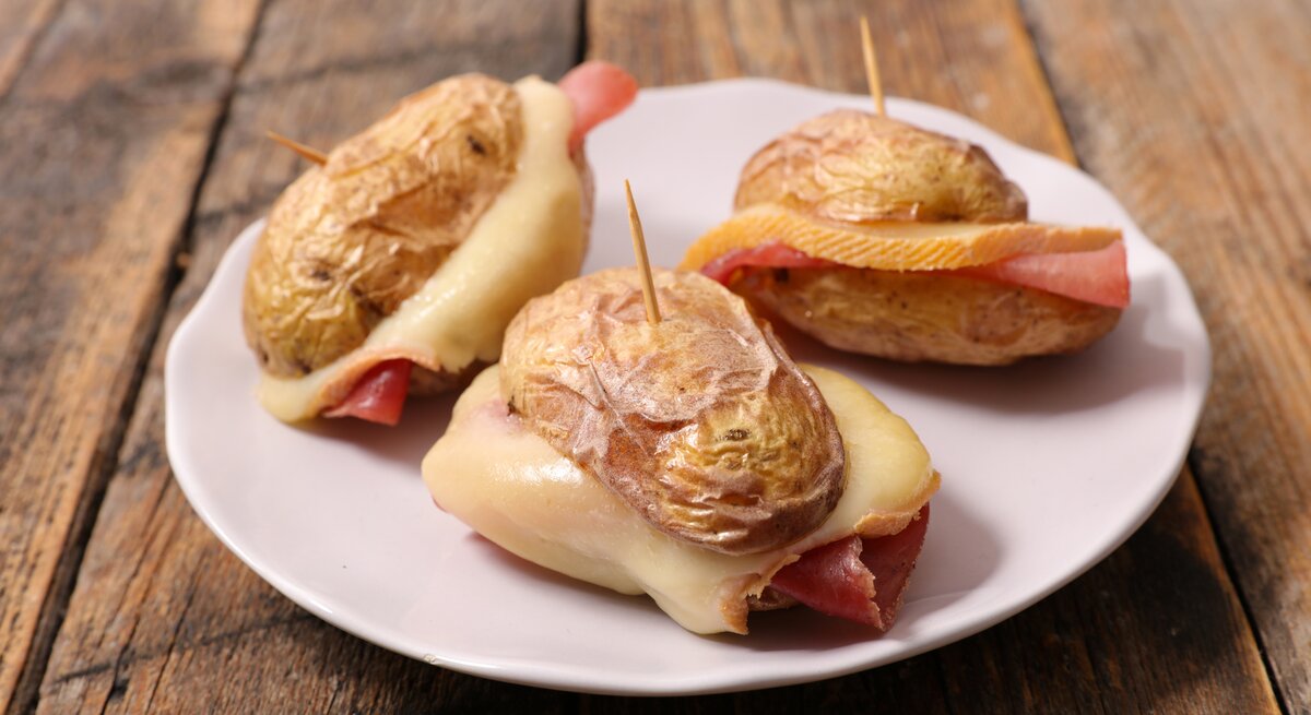 Mini-Burger aus Kartoffel belegt mit Schinken und Raclette-Käse. 