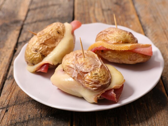 Mini-Burger aus Kartoffel belegt mit Schinken und Raclette-Käse.  | © Getty Images/margouillatphotos