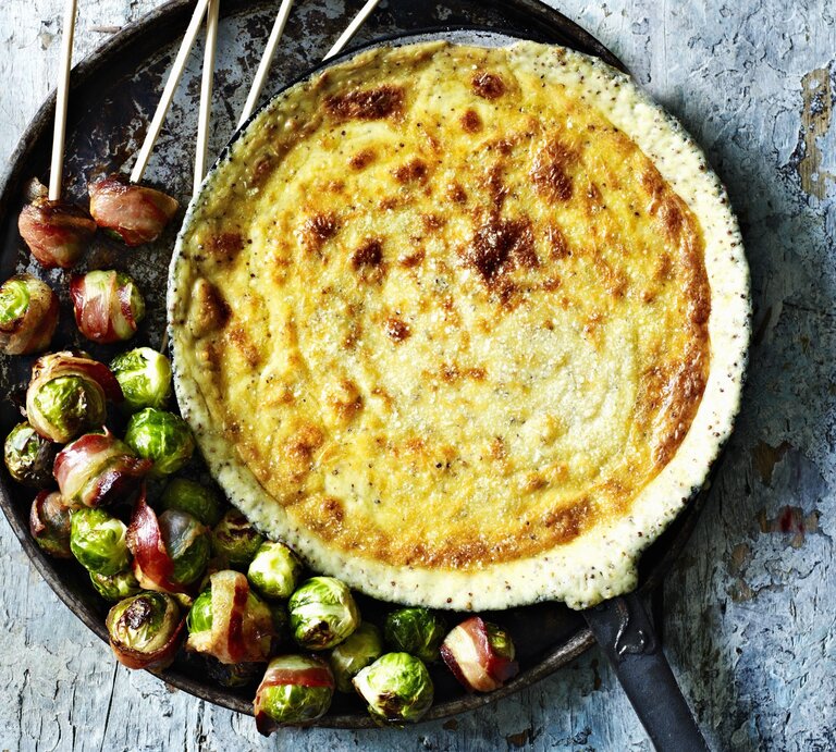 Gebackenes Gruyere-Senf-Fondue mit Rosenkohl im Speckmantel in der Draufsicht. | © StockFood / Immediate Media / Good Food