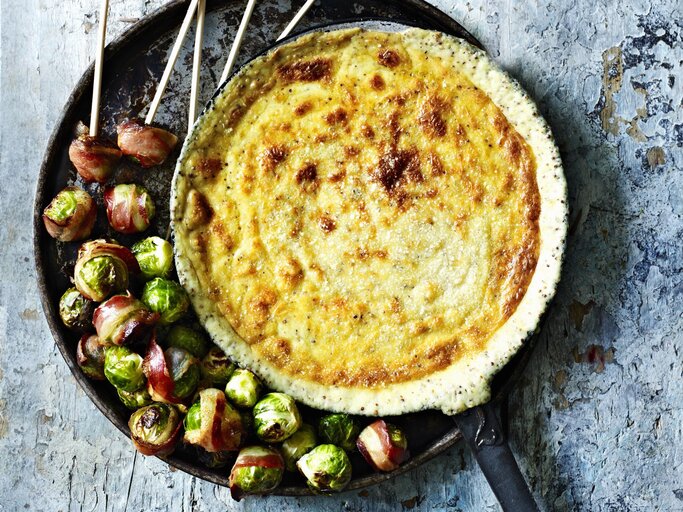 Gebackenes Gruyere-Senf-Fondue mit Rosenkohl im Speckmantel in der Draufsicht. | © StockFood / Immediate Media / Good Food