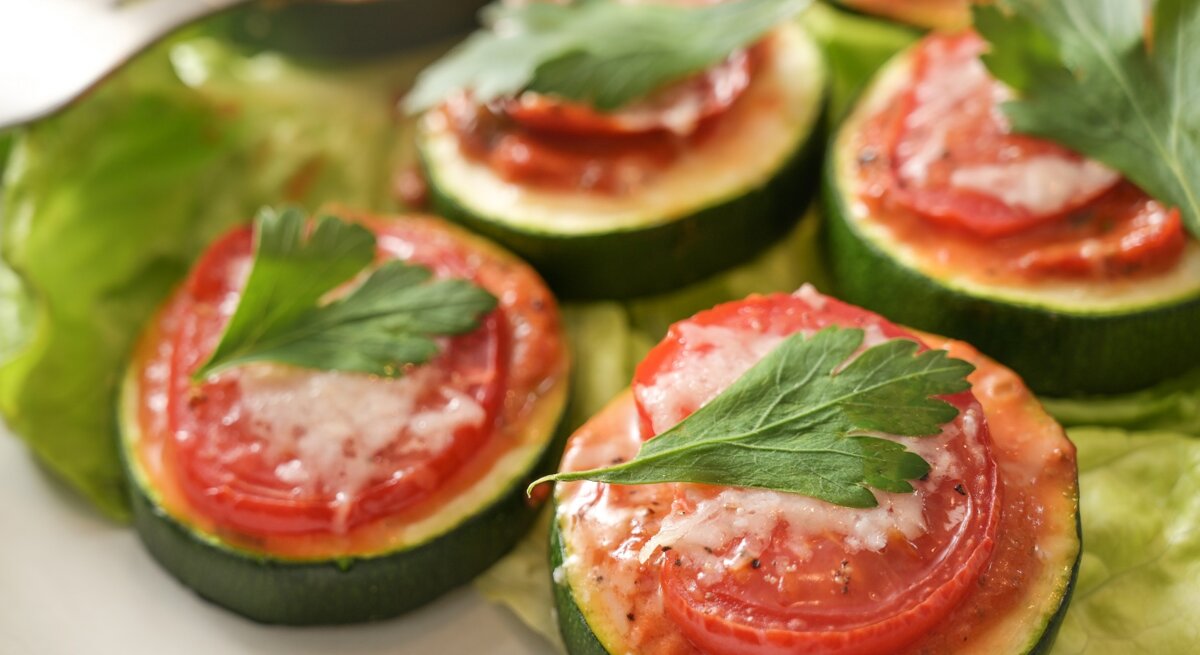 Zucchini-Bruschetta-Häppchen auf einem Teller, daneben eine Gabel.