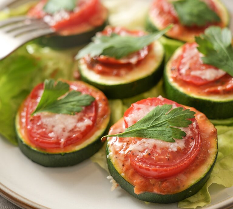 Zucchini-Bruschetta-Häppchen auf einem Teller, daneben eine Gabel. | © Adobe Stock/ Maren Winter