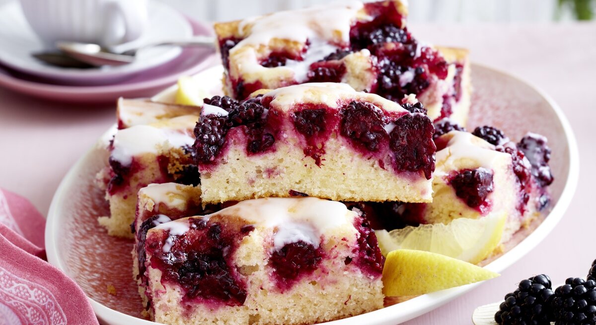 Brombeer-Joghurt-Kuchen auf einem rosa Teller.