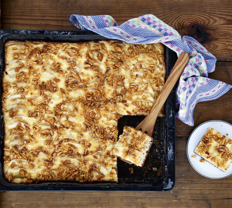 Apfelkuchen vom Blech mit Krokant, angeschnitten auf dem schwarzen Ofenblech serviert.  | © StockFood / für ZS Verlag / Skowronek, Julia