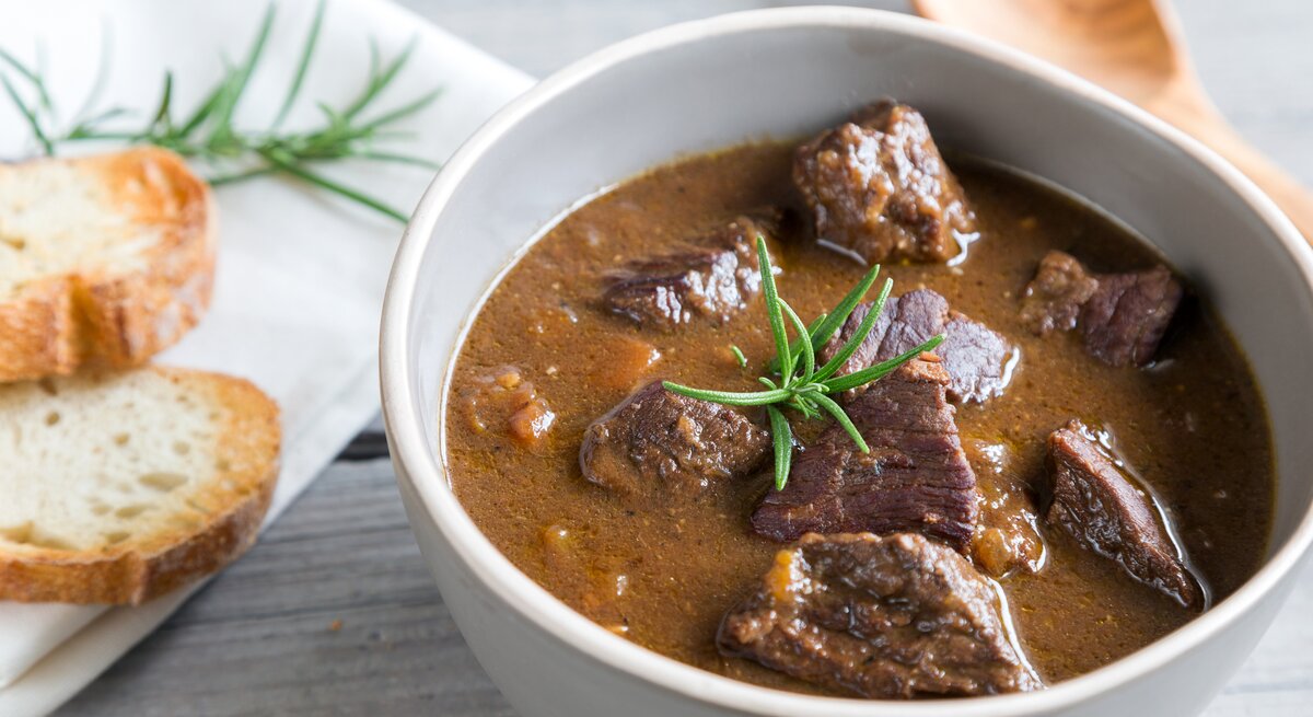 Gulasch in weißer Schüssel.
