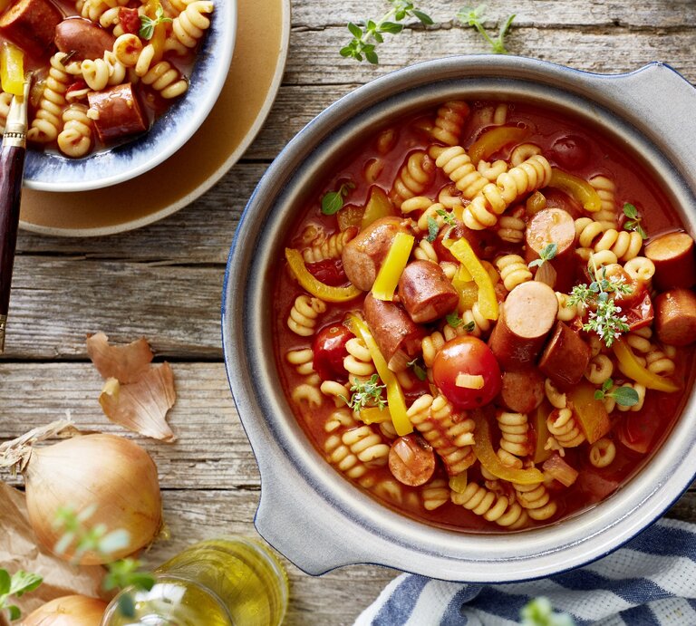 One-Pot-Wurstgulasch in Topf auf Holztisch.  | © EAT CLUB/Isabell Triemer