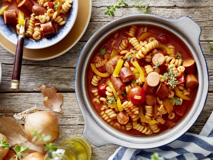 One-Pot-Wurstgulasch in Topf auf Holztisch.  | © EAT CLUB/Isabell Triemer