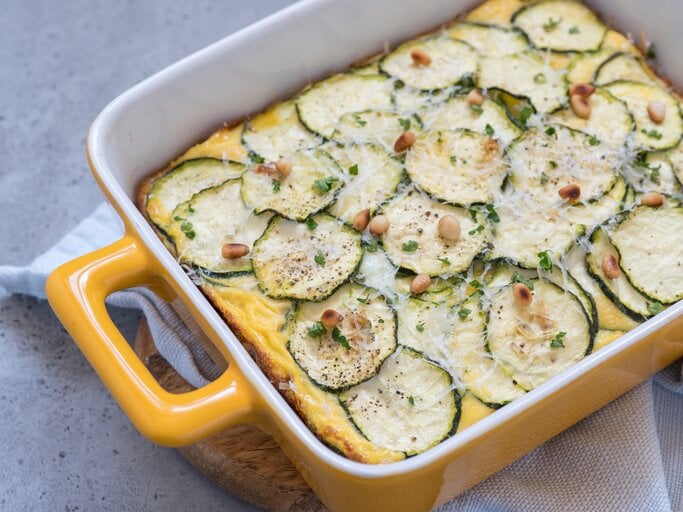 Zucchini-Auflauf mit Hackfleisch und Feta in gelber Auflaufform auf hellem Untergrund.  | © Getty Images/Azurita