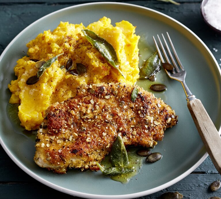 Knusper-Schnitzel mit Kürbisstampf auf Teller, belegt mit Salbei und Kürbiskernen.  | © EAT CLUB/Isabell Triemer
