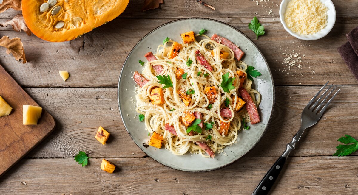 Kürbis-Carbonara auf Holztisch. 