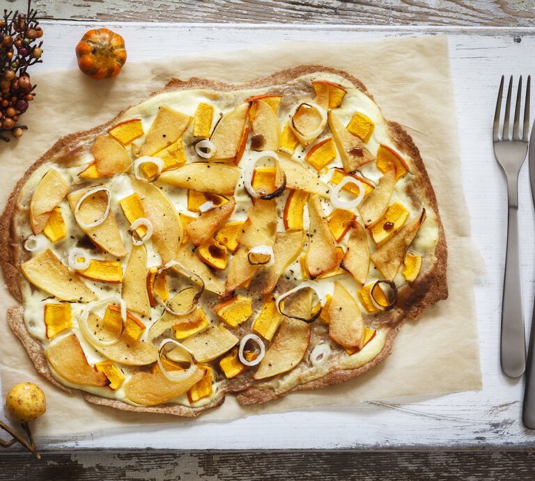 Kürbis-Quitte-Flammkuchen auf Holzbrett. | © Getty Images/ Westend61