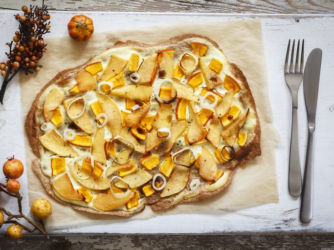 Kürbis-Quitte-Flammkuchen auf Holzbrett. | © Getty Images/ Westend61
