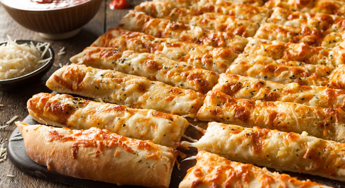 Blech mit in Stangen geschnittene Käse-Pizza umrundet von den Zutaten.