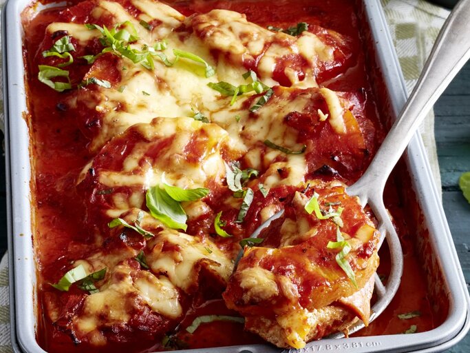 In einer Auflaufform ist eine Portion Schnitzel-Pizza Hawaii angerichtet. SIe ist mit Käse überbacken und sieht cremig aus. | © EAT CLUB / Isabell Triemer