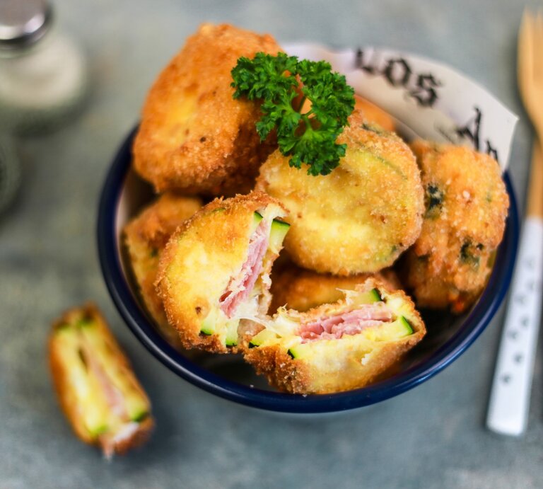 Cordon bleu mit Zucchini, Mozzarella und Schinken, angeschnitten serviert in einer großen Schale und garniert mit frischer Petersilie.  | © StockFood / Gargioni, Claudia