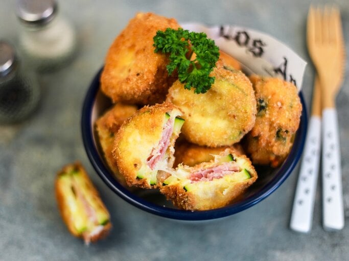 Cordon bleu mit Zucchini, Mozzarella und Schinken, angeschnitten serviert in einer großen Schale und garniert mit frischer Petersilie.  | © StockFood / Gargioni, Claudia
