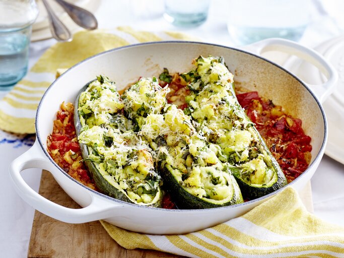 gefüllte Zucchini-Boote mit Kartoffelfüllung auf Tomatengemüse in einer runden Auflaufform. | © EAT CLUB/ Isabell Triemer