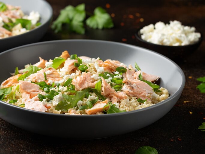 Eine graue Schüssel mit dem Salat auf einem dunklen Holztisch von der Seite fotografiert. Im Hintergrund eine weitere Schüssel mit mehr Salat und ein kleines Schälchen mit Feta. | © Shutterstock/ DronG 