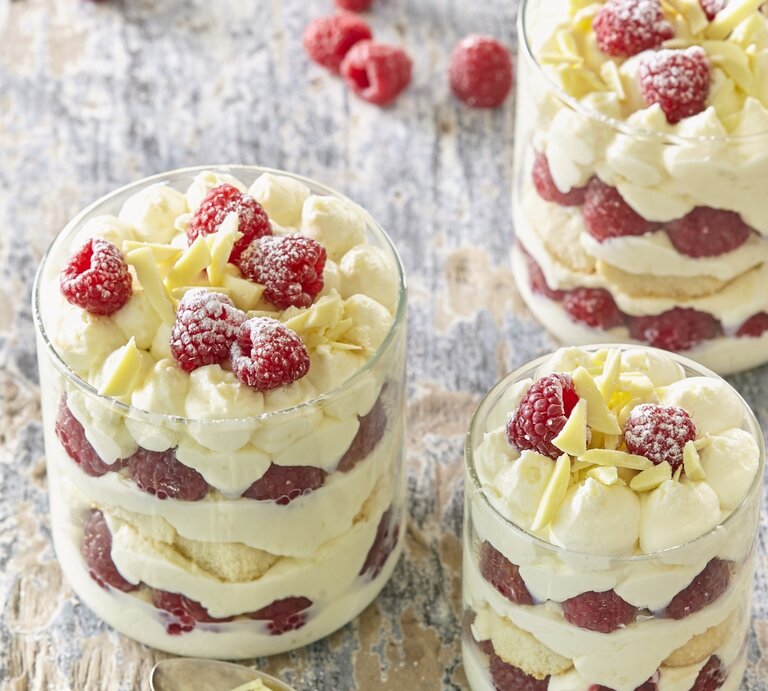Drei kleine Gläser mit Himbeer-Tiramisu. Das Ganze auf einem hölzernen Untergrund.  | © StockFood / Profimedia