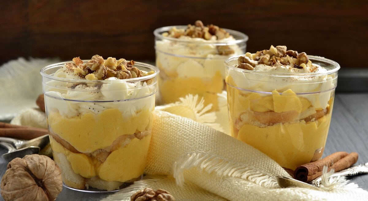 Drei Gläser mit Kürbis-Tiramisu auf einem grauen Tisch.
