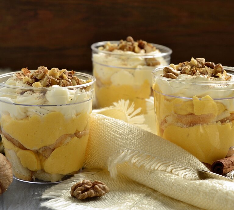 Drei Gläser mit Kürbis-Tiramisu auf einem grauen Tisch. | © Shutterstock/Nataliia Leontieva