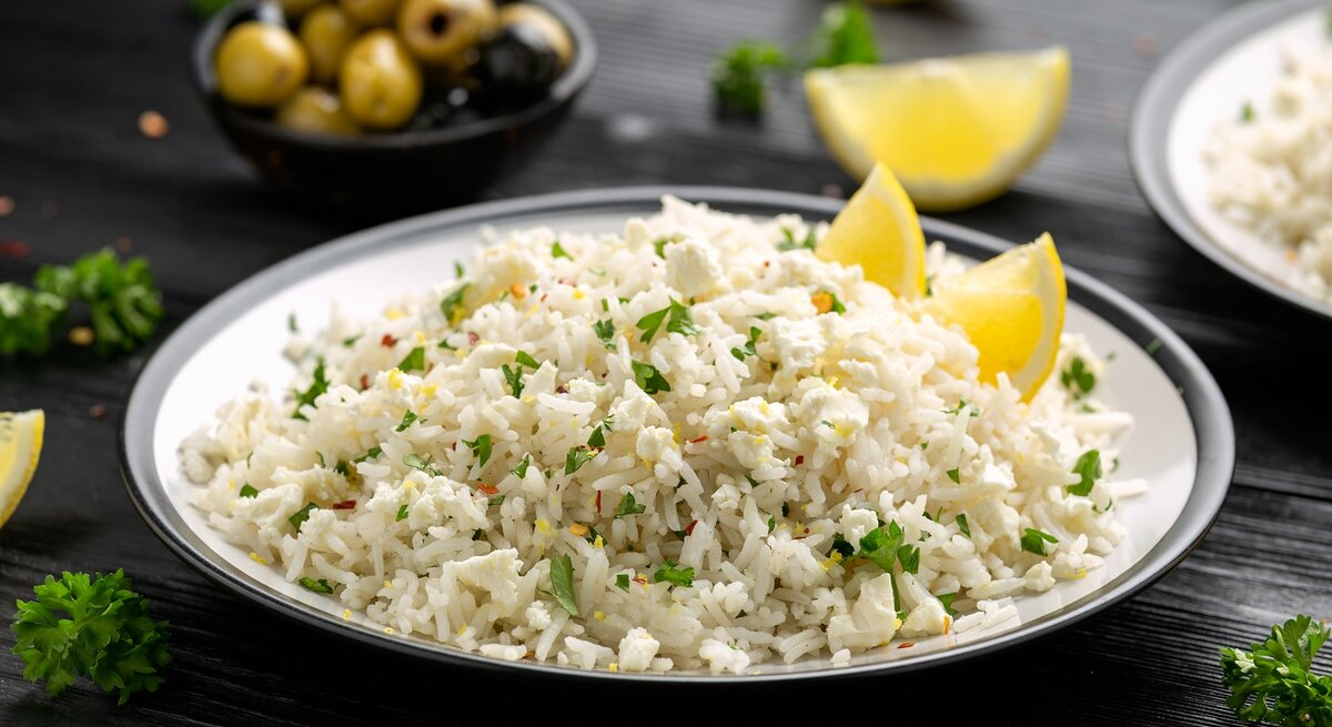 Ein Teller mit griechischem Feta-Reis auf einem schwarzen Tisch.