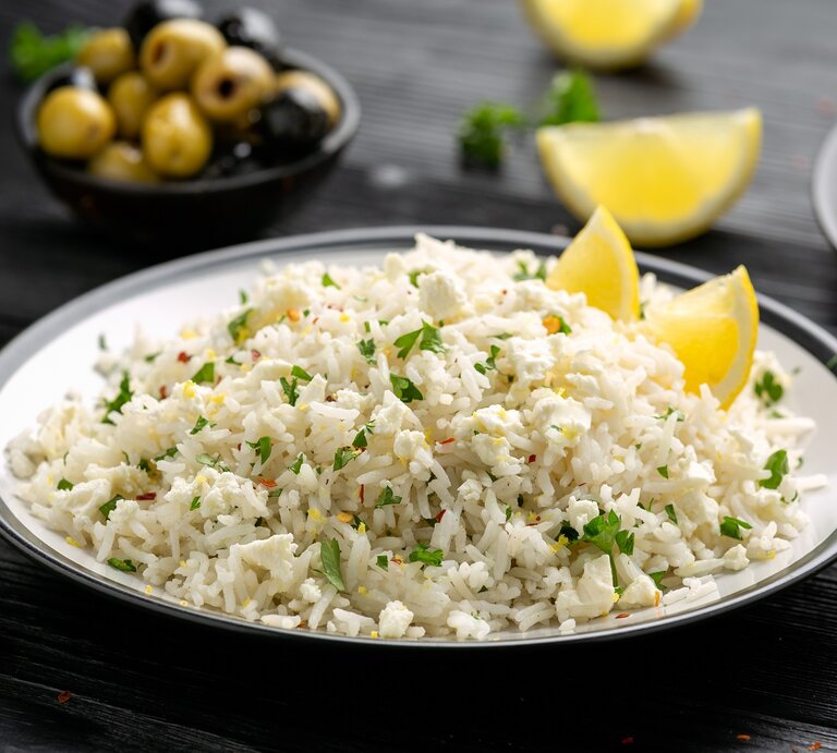 Ein Teller mit griechischem Feta-Reis auf einem schwarzen Tisch. | © Shutterstock/DronG