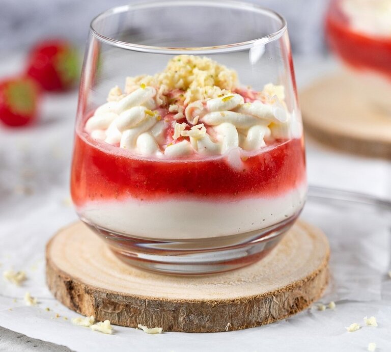 In einem Glas ist ein Spaghetti-Eis mit Mascarpone und Erdbeersauce angerichtet. Es ist mit weißer Schokolade bestreut.  | © StockFood / Diana, Ruchser