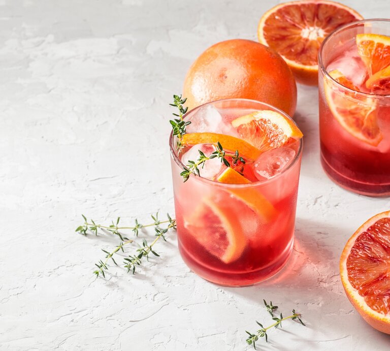Zwei Gläser mit Campari Spritz auf hellem Untergrund. | © Shutterstock/UliAb